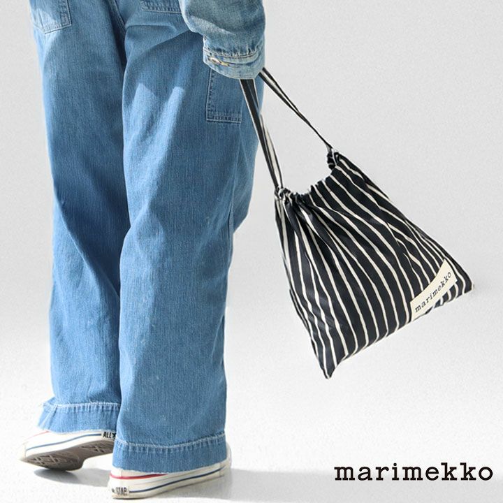 デニムスタイルの人物がMarimekko ストライプ柄ドローストリングバッグを持つ後ろ姿。カジュアルなコーディネートにマッチするブラック×ホワイトの巾着バッグ
